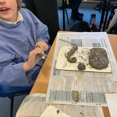 Children making clay lizards